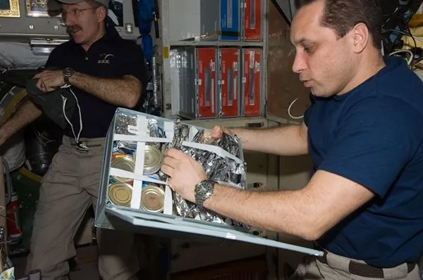 Российский космонавт Антон Шкаплеров выбирает продукты из пищевого контейнера